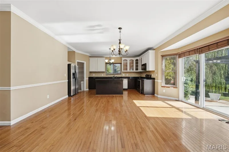 Looking into the kitchen from the 2-story  great room. More character details with crown molding and chair rail. — 1615 Wainscott Court, O'Fallon, MO 63366