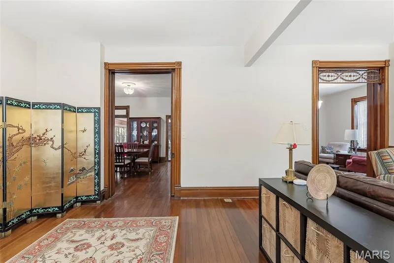 Polished wood flooring, natural wood door casings with decorative corner blocks, and intricate wood fretwork trim — 711 N 5th Street, St Charles, MO 63301