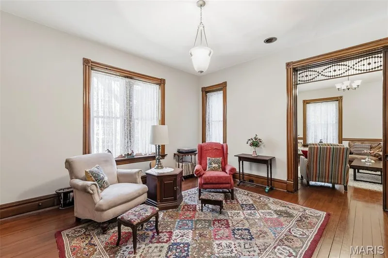 Stained wood trim, original-style decorative woodwork, polished wood flooring, pendant lighting, and multi-pane windows — 711 N 5th Street, St Charles, MO 63301