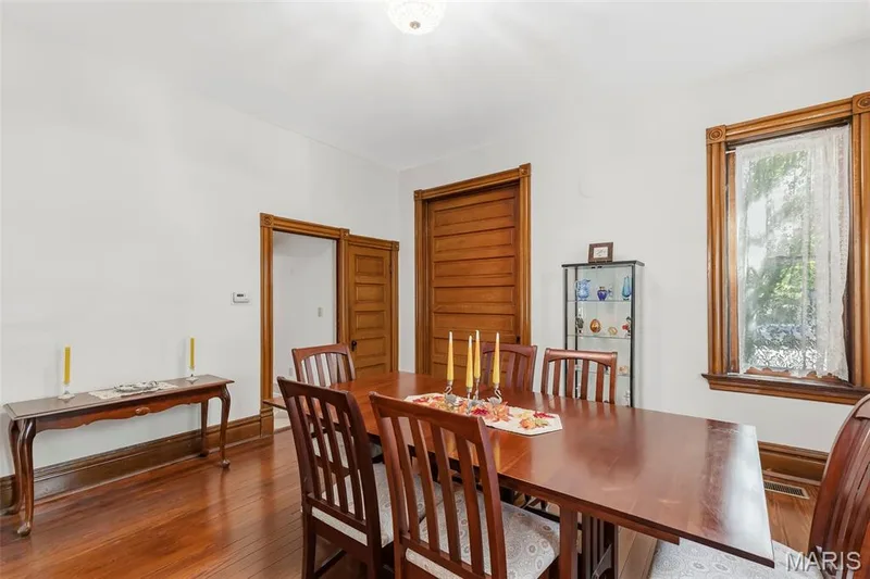 Hardwood flooring, natural wood trim, multi-panel wooden doors, and decorative window casing — 711 N 5th Street, St Charles, MO 63301