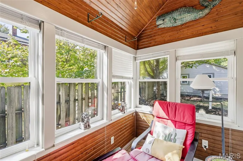 Sunroom featuring natural wood-planked walls and vaulted ceiling, multiple large windows, and blinds — 711 N 5th Street, St Charles, MO 63301