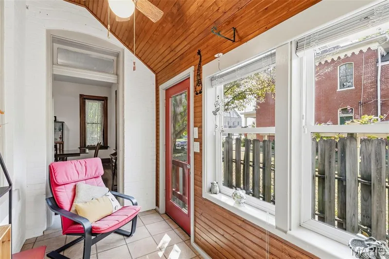 Enclosed porch featuring tongue-and-groove wood wall paneling, vaulted wood-finish ceiling, ceramic tile flooring, and multiple windows — 711 N 5th Street, St Charles, MO 63301