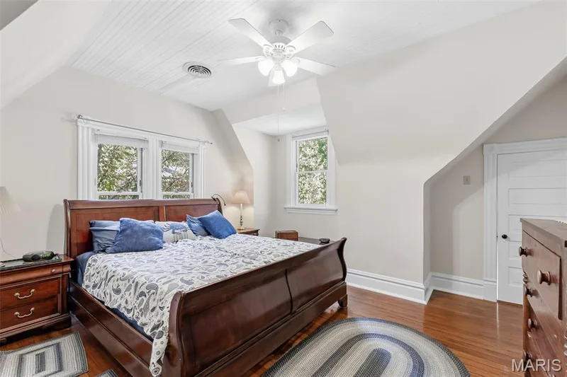 Bedroom featuring beadboard ceiling, wood-finish flooring, multi-pane windows, and a ceiling-mounted light fixture — 711 N 5th Street, St Charles, MO 63301