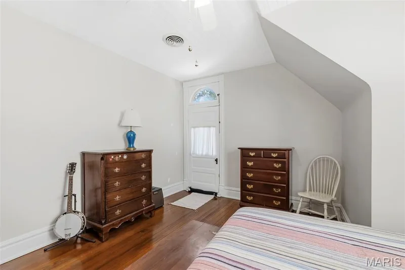 Wood-finish flooring, vaulted ceiling, and exterior door featuring an arched transom window — 711 N 5th Street, St Charles, MO 63301