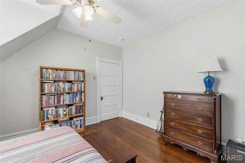 Room featuring wood-finish flooring, a beadboard ceiling, and a five-panel interior door — 711 N 5th Street, St Charles, MO 63301