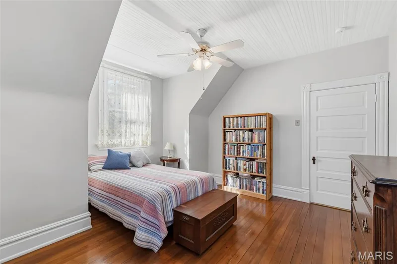 Beadboard ceiling, wood flooring, ceiling fan with integrated lighting, and multi-panel door with architectural casing — 711 N 5th Street, St Charles, MO 63301
