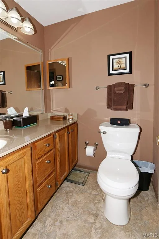 Vanity with wood-finish cabinetry, light-toned countertop, and undermount sink — 1738 Sun Drop Drive, St Charles, MO 63303