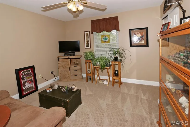 Ceiling fan with integrated lighting, neutral-toned walls, and carpeted flooring — 1738 Sun Drop Drive, St Charles, MO 63303