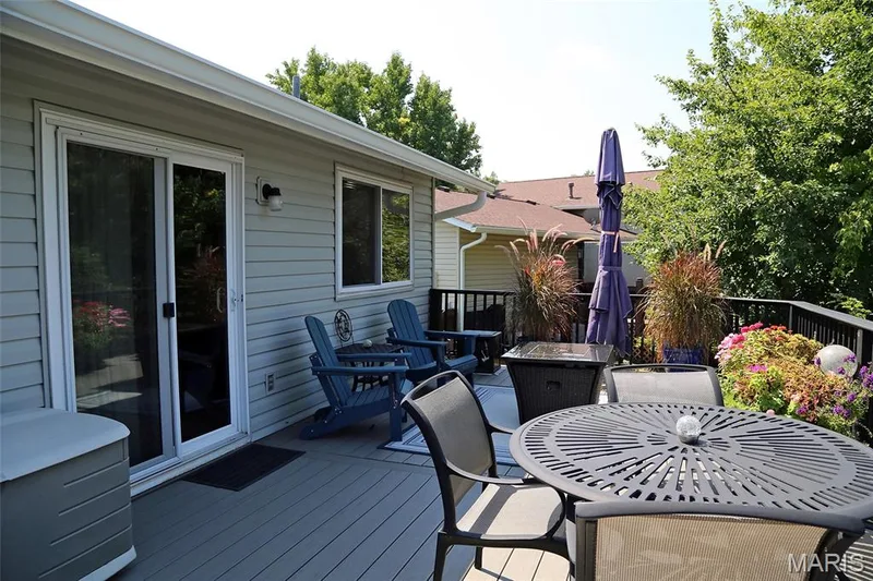 Expansive deck featuring light-toned siding, sliding glass door access, and a black railing system — 1738 Sun Drop Drive, St Charles, MO 63303