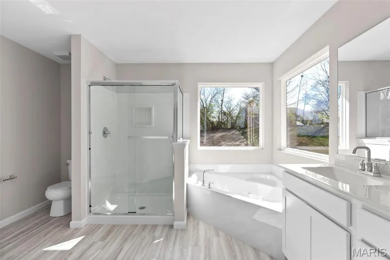 Full bathroom featuring hardwood / wood-style flooring, toilet, separate shower and tub, and vanity — 2 Hermitage II at Elm Crossing, St Charles, MO 63301