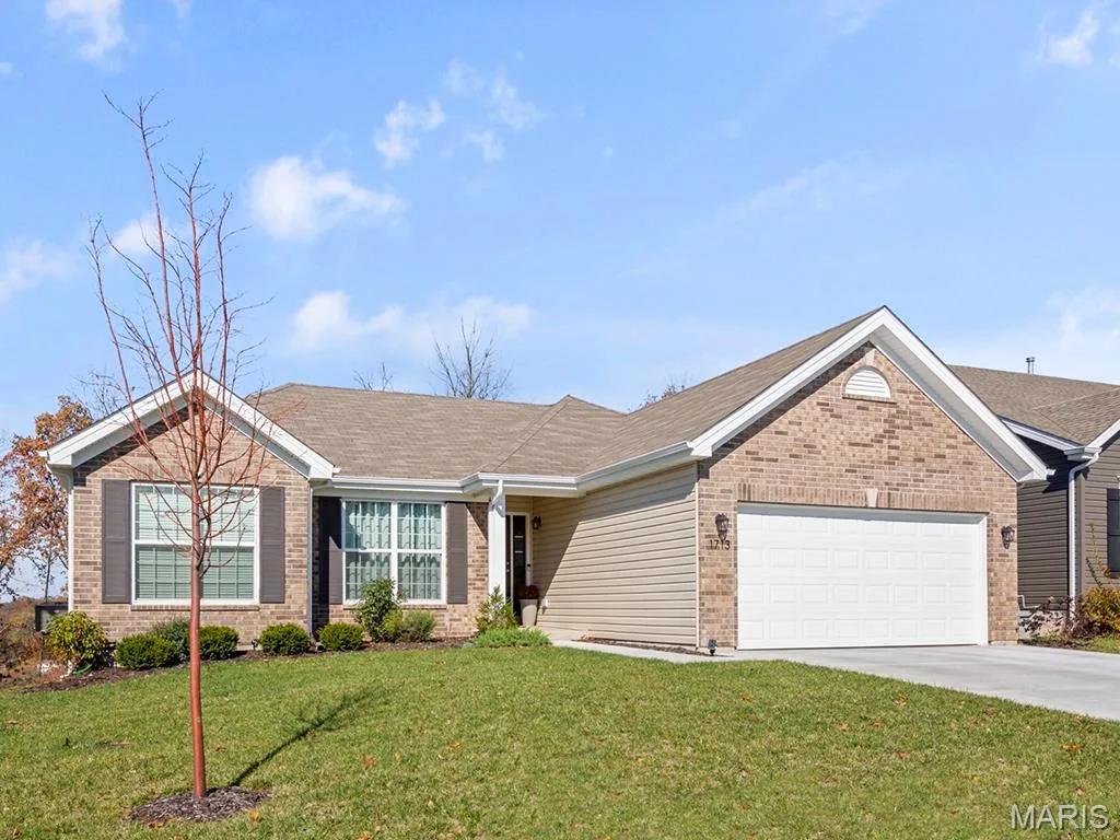 Ranch-style house featuring a front lawn and a garage — 2 Hickory at Elm Crossing, St Charles, MO 63301