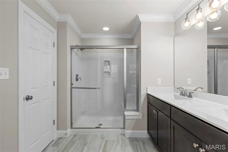 Bathroom with crown molding, vanity, and a shower with shower door — 2 Maple at Elm Crossing, St Charles, MO 63301