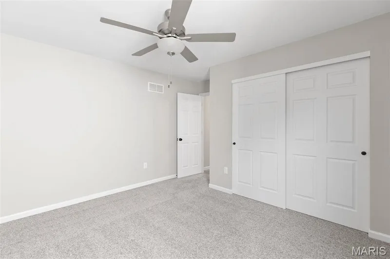 Unfurnished bedroom featuring light carpet, a closet, and ceiling fan — 2 Maple at Elm Crossing, St Charles, MO 63301