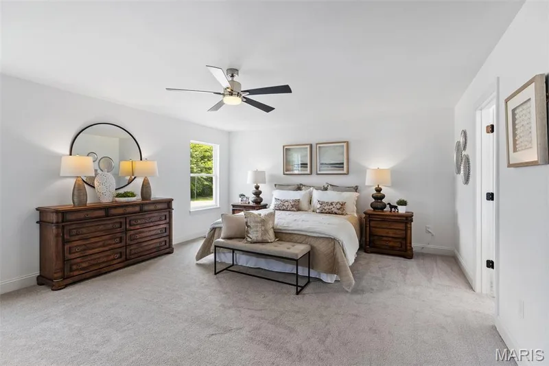 Bedroom featuring ceiling fan and light carpet — 2 Nottingham at Elm Crossing, St Charles, MO 63301