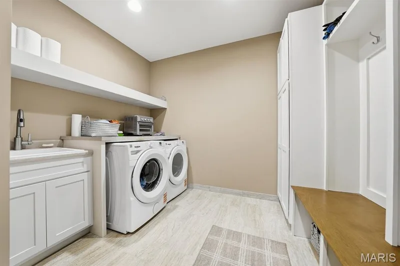 Main floor laundry with ceramic tile and built ins — 117 Trail Creek Court, St Charles, MO 63304