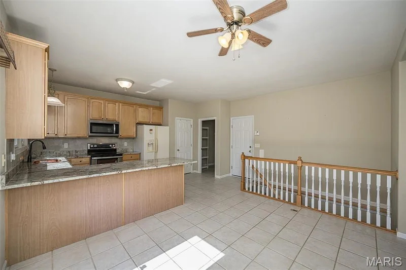 Next to the refrigerator is a large pantry.  The open door leads to a private Laundry Room on the main level. — 84 Reuben Court, O'Fallon, MO 63376