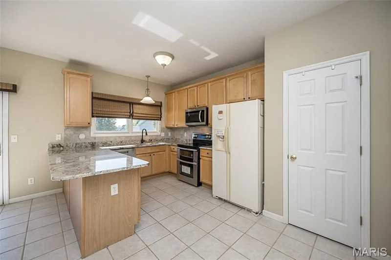 This photo shows of the stunning granite. Door to the right to the pantry. — 84 Reuben Court, O'Fallon, MO 63376
