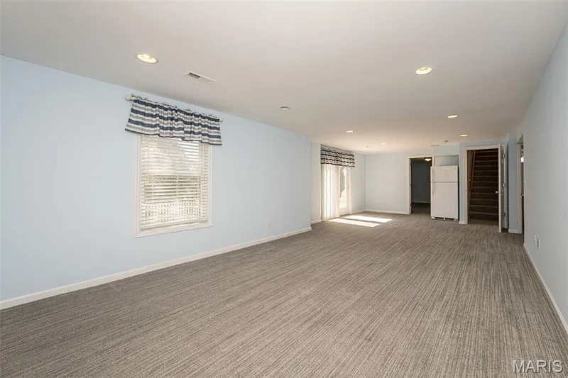 A view to the stairs from the main level.  The patio doors lead to the terrace level patio. — 84 Reuben Court, O'Fallon, MO 63376