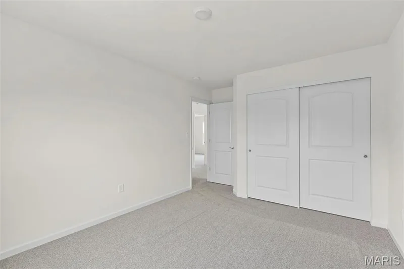 Unfurnished bedroom with light carpet and a closet — 2 Sequoia at Elm Crossing, St Charles, MO 63301