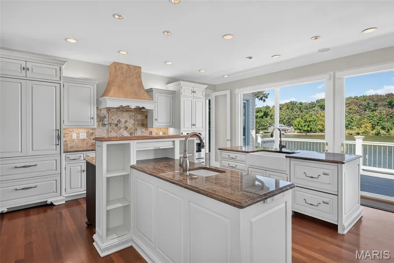 Kitchen with multiple islands, granite, hardwood and built in refrigerator — 33 Moorings Drive, Lake St. Louis, MO 63367