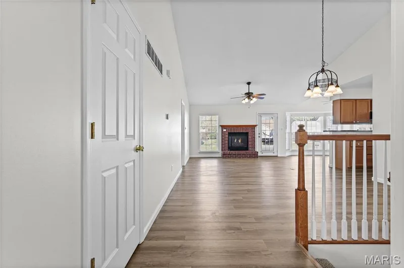 Vaulted ceilings, wood-finish flooring, brick fireplace, ceiling fan, and pendant light fixture — 2006 Chapel Hill Crossing, St Peters, MO 63376