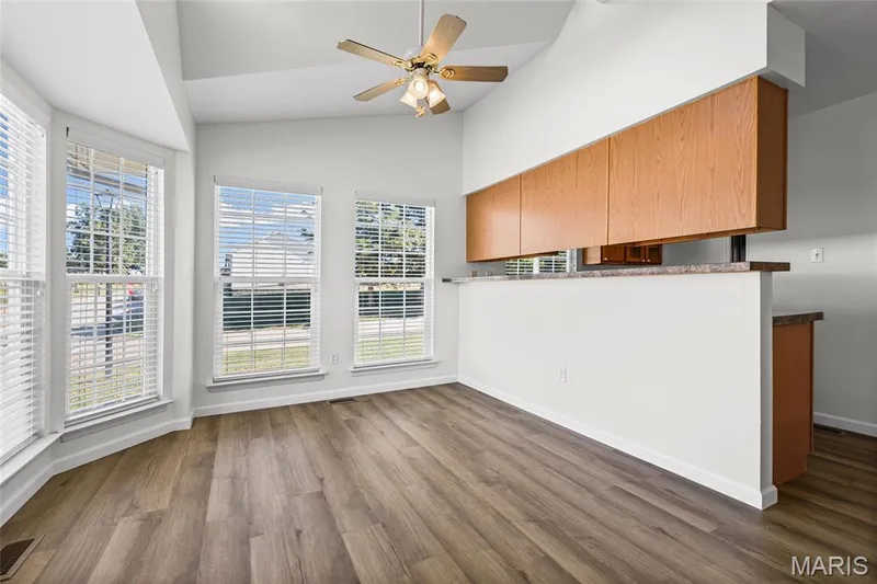 Vaulted ceiling with a ceiling fan, wood-finish flooring, bay windows, and built-in cabinetry with a countertop — 2006 Chapel Hill Crossing, St Peters, MO 63376