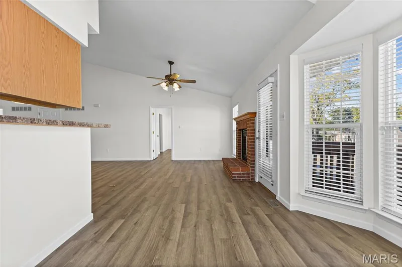 Vaulted ceiling, wood-finish flooring, brick fireplace, bay windows, and a ceiling fan — 2006 Chapel Hill Crossing, St Peters, MO 63376