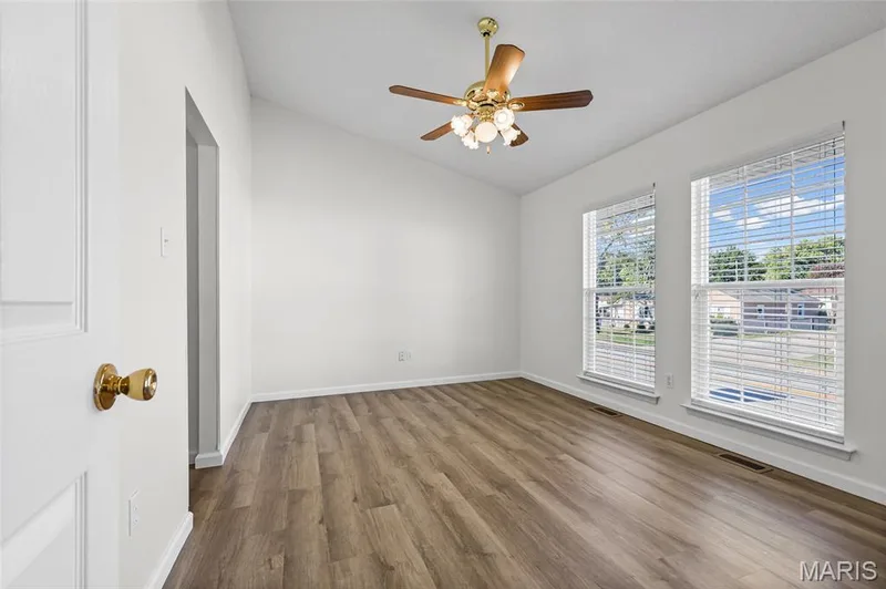 Vaulted ceiling with a ceiling fan light fixture, wood-finish flooring, and two windows with blinds — 2006 Chapel Hill Crossing, St Peters, MO 63376