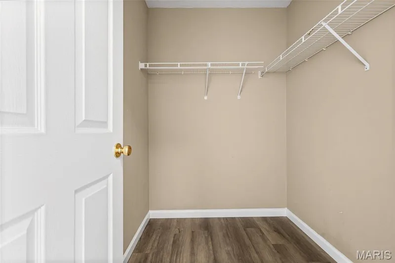 Interior space featuring wire shelving, wood-finish flooring, and a paneled door with brass hardware — 2006 Chapel Hill Crossing, St Peters, MO 63376