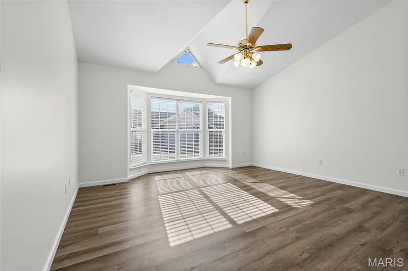 Vaulted ceiling with a ceiling fan, bay window with blinds, wood-finish flooring, and a skylight — 2006 Chapel Hill Crossing, St Peters, MO 63376