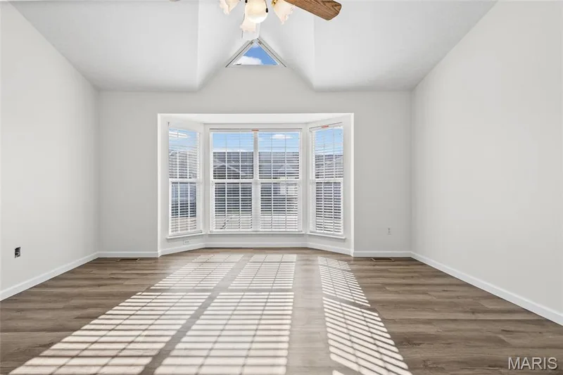 Bay window with white blinds, wood-finish flooring, vaulted ceiling, and an integrated ceiling fan — 2006 Chapel Hill Crossing, St Peters, MO 63376