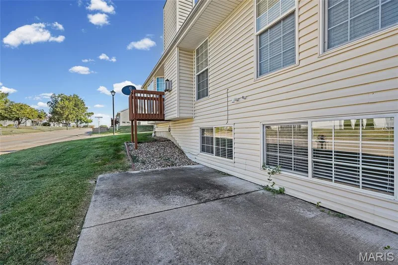 Exterior siding with multiple windows, concrete patio area, and a raised wooden deck — 2006 Chapel Hill Crossing, St Peters, MO 63376