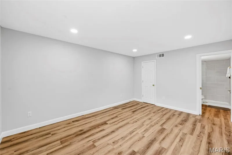 Wood-finish flooring, recessed lighting, white trim, white interior door, and light gray wall paint — 1410 Heritage Landing #106, St Charles, MO 63303