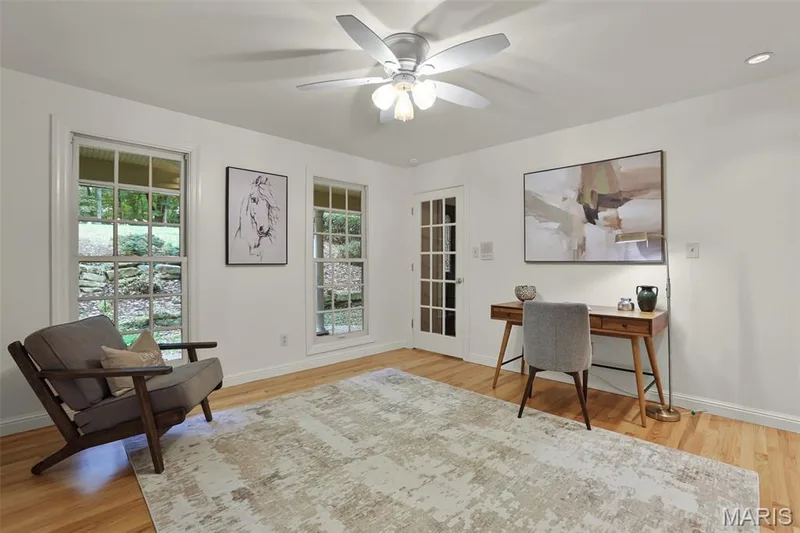 Wood-finish flooring, multi-pane windows, ceiling fan with integrated lighting, and a multi-pane glass door — 229 Quail Run Drive, Defiance, MO 63341