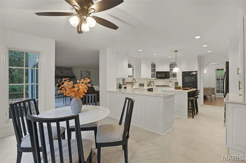 Kitchen featuring white cabinetry, stone-finish countertops, a central island with built-in seating, recessed lighting, and tile flooring — 229 Quail Run Drive, Defiance, MO 63341