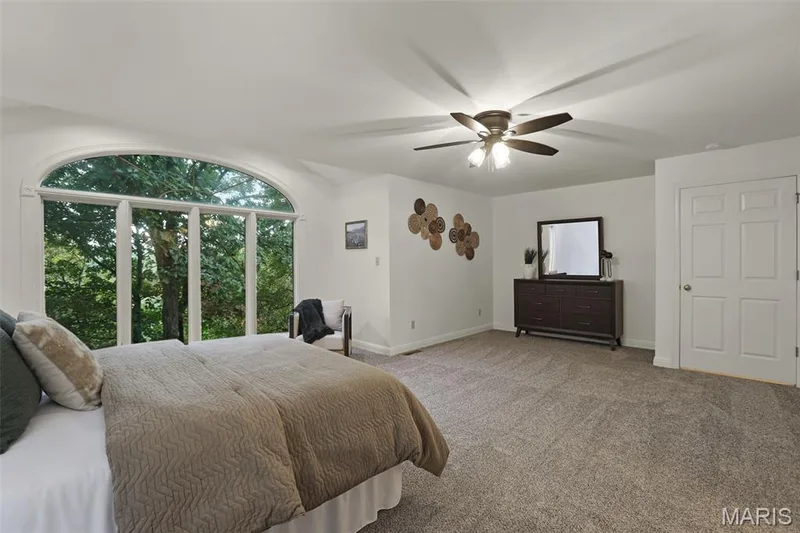 Arched window assembly, neutral wall-to-wall carpeting, and a multi-blade ceiling fan with integrated lighting — 229 Quail Run Drive, Defiance, MO 63341