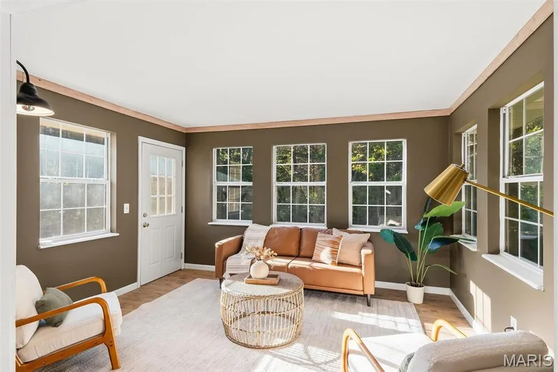 Bonus area featuring multi-pane windows, wood trim accents, a glass-panel exterior door, and wall-mounted lighting — 10341 Rose Lane, Foristell, MO 63348