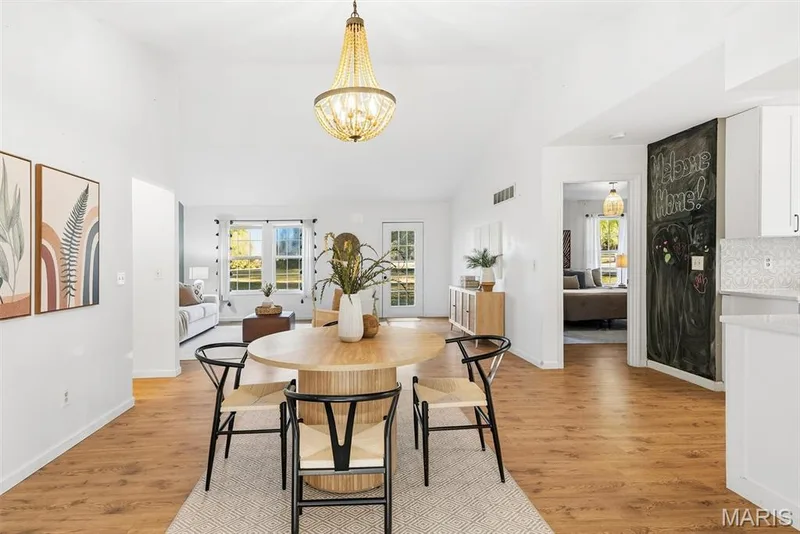 Vaulted ceiling with a beaded chandelier, wood-finish flooring, and a built-in chalkboard wall — 10341 Rose Lane, Foristell, MO 63348