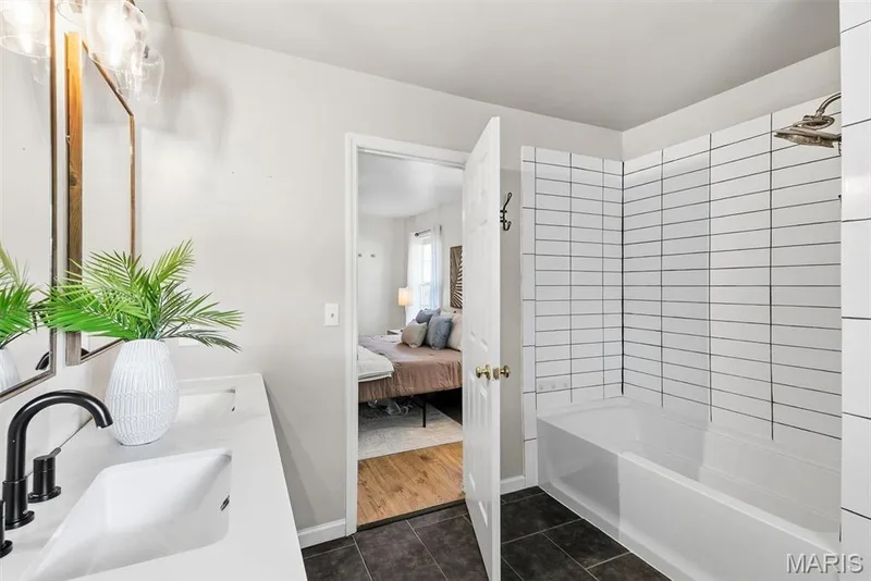 Primary Bath with Double vanity with rectangular undermount sinks and quartz countertops, matte black plumbing fixtures, and a tub-shower combination with floor-to-ceiling subway tile surround — 10341 Rose Lane, Foristell, MO 63348