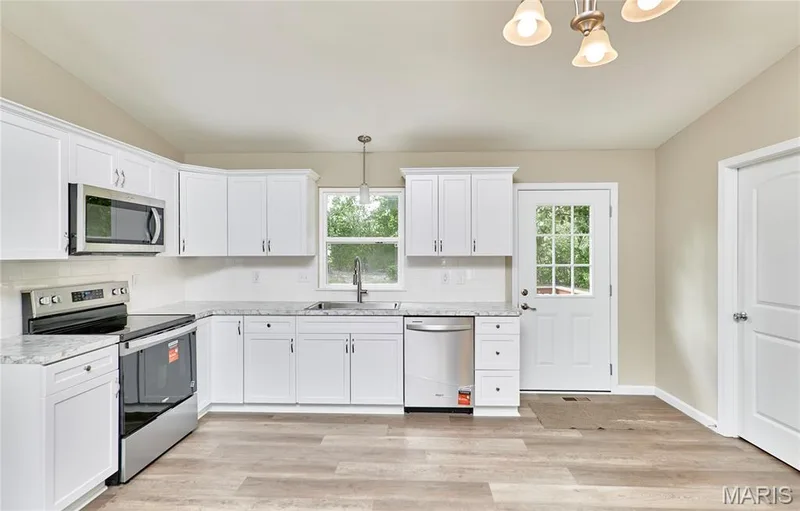 Another shot of the new kitchen you will enjoy.  Plenty of room to work and entertain.  The door to the righ goes to the Laundry Room — 408 Raymond Drive, O'Fallon, MO 63366