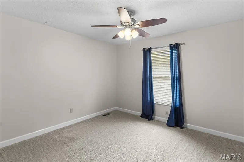 Neutral wall tones, wall-to-wall carpeting, and a ceiling fan with multi-light fixture — 838 Emerald Place Drive, St Charles, MO 63304