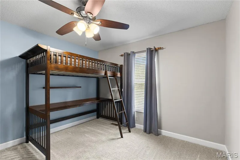 Room featuring neutral carpeting, a ceiling fan with integrated lighting, and a single window with horizontal blinds — 838 Emerald Place Drive, St Charles, MO 63304