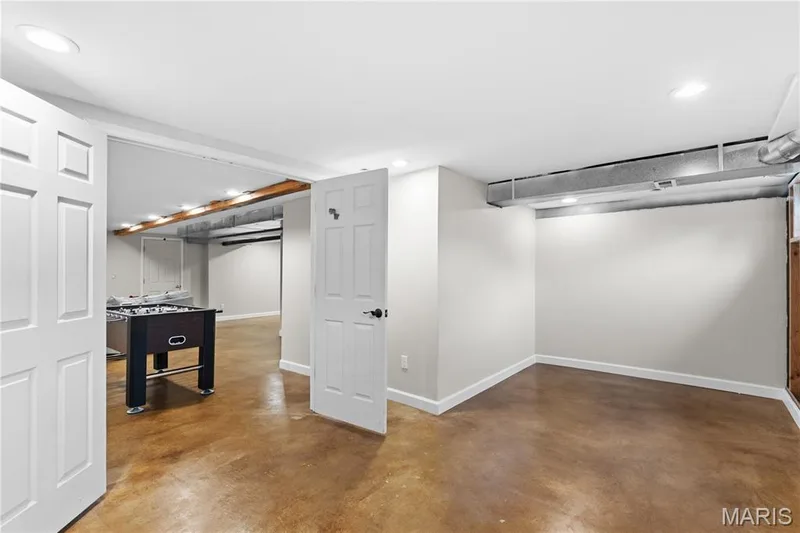 Finished interior space featuring neutral painted walls, recessed lighting, six-panel doors, and concrete flooring — 838 Emerald Place Drive, St Charles, MO 63304