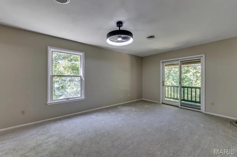 The master bedroom offers a sliding door on to the front balcony and light from the side as well. — 3030 Woodlands, Wildwood, MO 63038