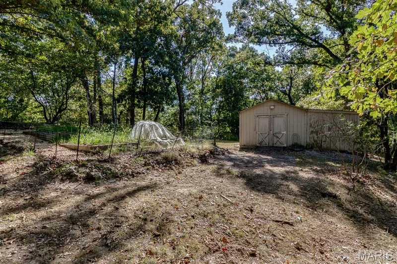 This shed blends into the landscape and exists to keep the garage free of lawn equipment. — 3030 Woodlands, Wildwood, MO 63038