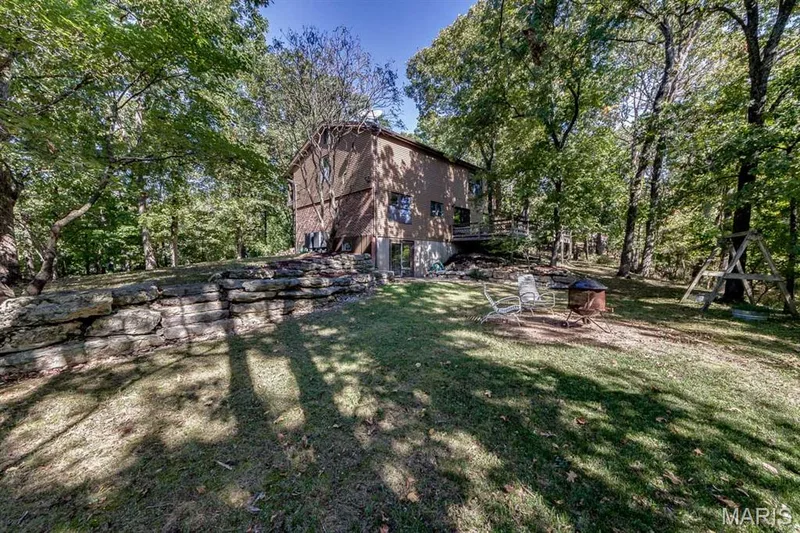 These large rock outcroppings are beautiful.  This yard has lots of perennials that will pop up in the spring: iris, lily of the valley, peony, daffodils, etc.  These are beautiful sprinkled amongst the rocks and the greening of the trees! — 3030 Woodlands, Wildwood, MO 63038