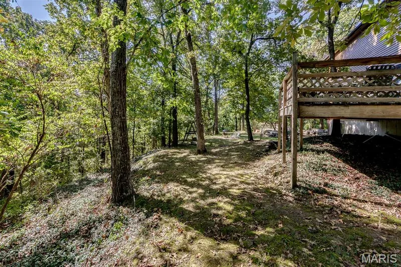 Beyond the deck, the property slopes down into a creek bed that's dry most of the time. — 3030 Woodlands, Wildwood, MO 63038