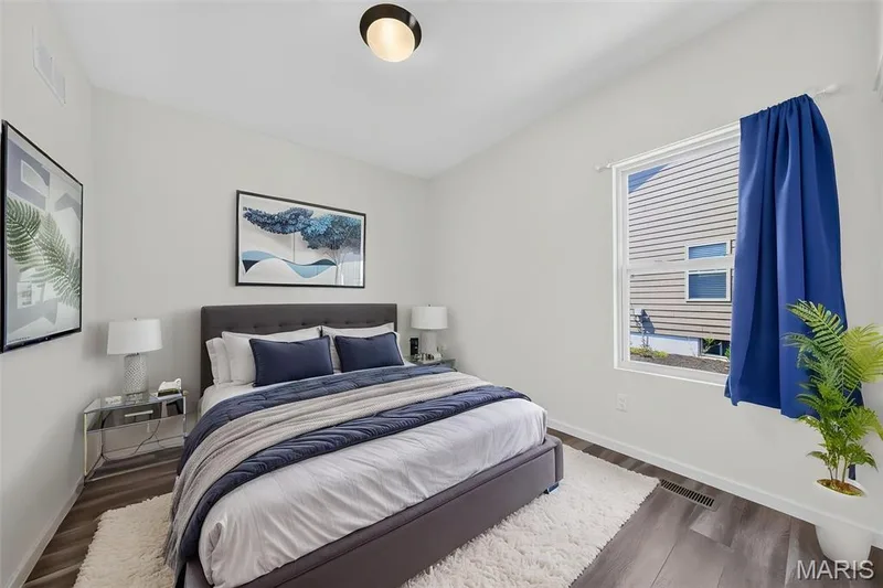Light-filled room featuring wood-finish flooring, a contemporary ceiling light fixture, and a large window — 622 Cruden Bay Court, Dardenne Prairie, MO 63368