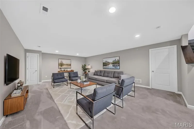 Spacious room featuring neutral paint, gray carpeting, recessed lighting, and white paneled doors — 622 Cruden Bay Court, Dardenne Prairie, MO 63368