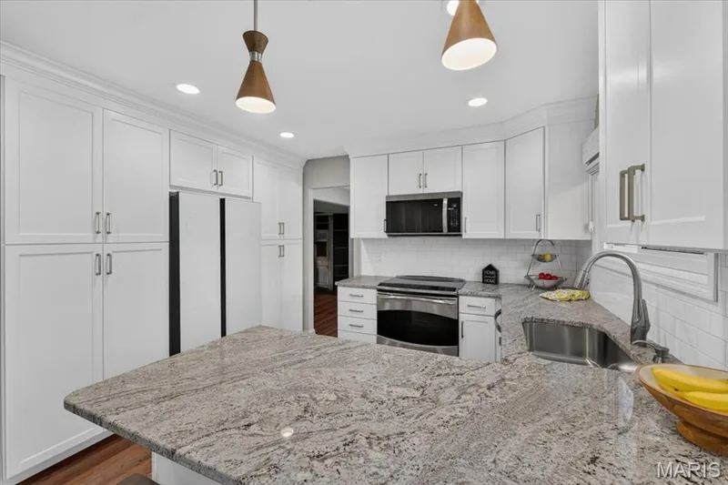 You'll appreciate the granite countertops and breakfast bar, plus updated recessed and island lighting. — 15056 Isleview Drive, Chesterfield, MO 63017